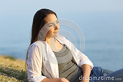 Woman contemplating on the grass on a beach Stock Photo