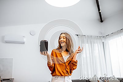 Woman controlling home devices with a voice commands Stock Photo