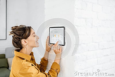 Woman controlling home with a digital touch screen Stock Photo