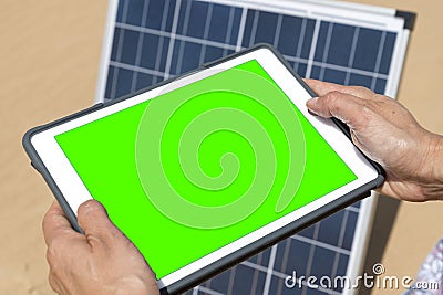 woman controls her solar panel via electronic tablet with green screen, green energy concept Stock Photo