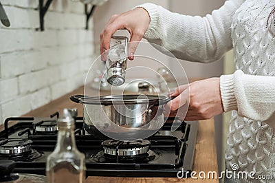 Woman cooking delicious mulled wine at stove closeup. process of making mulled wine at home in kitchen Stock Photo