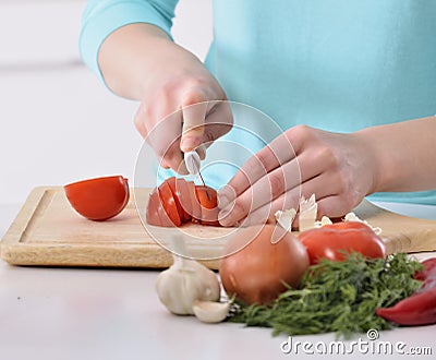 Woman cooking in new kitchen making healthy food with vegetables. Stock Photo