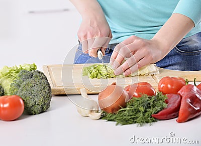 Woman cooking in new kitchen making healthy food with vegetables. Stock Photo