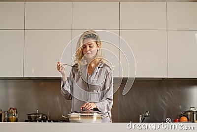 Woman with cooking pot. Sexy woman in the kitchen in the morning and cooking healthy food. Sensual housewife. Stock Photo