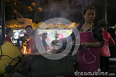 A woman cooking on a stall in a night market in Hanoi Editorial Stock Photo