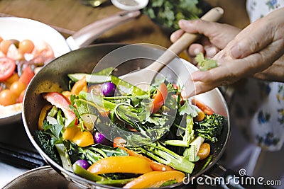 Woman cooking stir fried vegetables Stock Photo