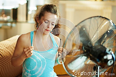 Woman cooling down using fan suffering from summer heat Stock Photo