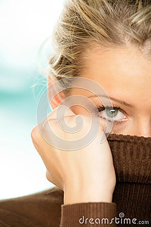 Woman covering face with turtleneck Stock Photo