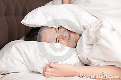 Woman covering head with pillow because of noise Stock Photo