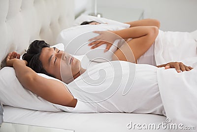 Woman covering her ears as partner is snoring loudly Stock Photo