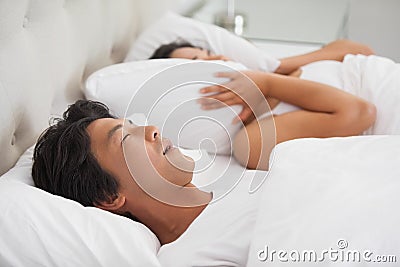 Woman covering her ears as partner is snoring loudly Stock Photo