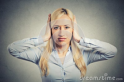 Woman covering her ears avoiding unpleasant rude situation Stock Photo