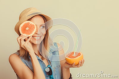 Woman covering her eye with grapefruit. Fun summer Stock Photo