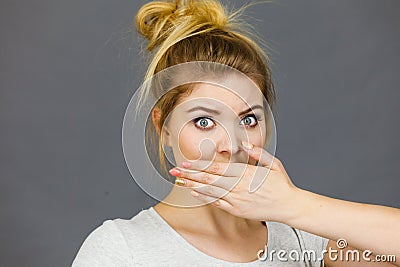 Woman covering her mouth with hand Stock Photo