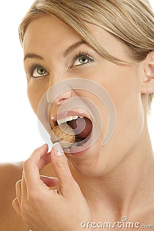 Woman cracking walnut with her teeth Stock Photo