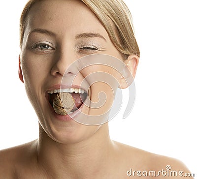 Woman cracking walnut with her teeth Stock Photo