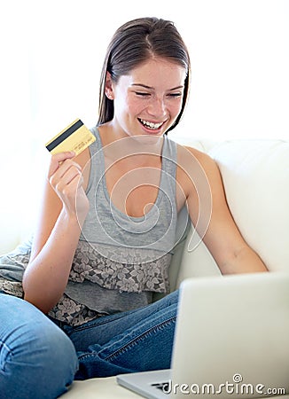 Woman, credit card and laptop on sofa for online shopping sale, e commerce discount or cashback bonus at home. Excited Stock Photo