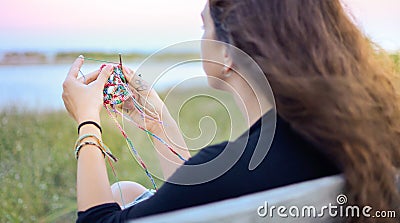 Woman crocheting by the lake Stock Photo