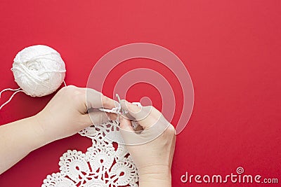 A woman crocheting white lace doily. Cotton yarn, top view of crochet yarn ball and crochet hook Stock Photo