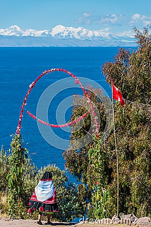 Woman crossing flowers gateway Taquile Island Andes Puno Peru Stock Photo