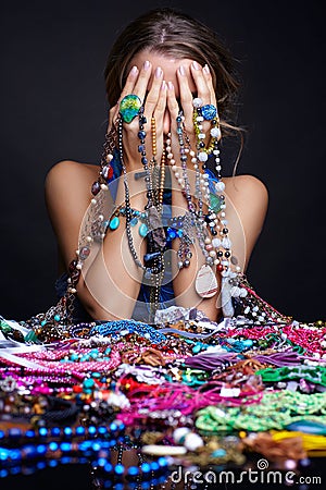 Woman crying over heap of jewelry and bijouterie Stock Photo