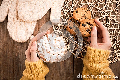 Woman with cup of delicious marshmallow cocoa and cookies at wooden table, top view Stock Photo