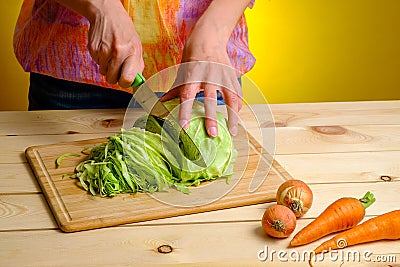 Woman cutting cabbage on wooden board Stock Photo