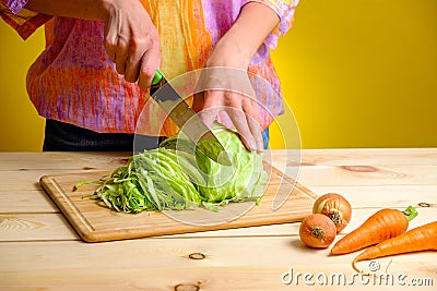 Woman cutting cabbage on wooden board Stock Photo