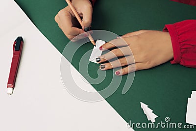 Woman cutting Christmas tree for Noel decoration. Flatlay Stock Photo