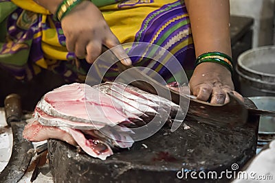 Woman cutting fish outdoor in Mumbai, India Stock Photo