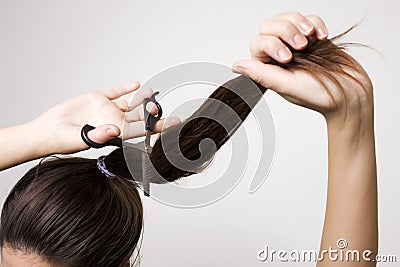 Woman cutting her ponytail Stock Photo