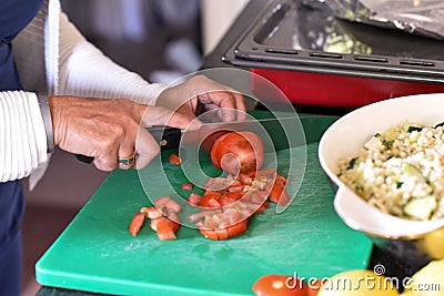 Woman is cutting tomatoes Stock Photo