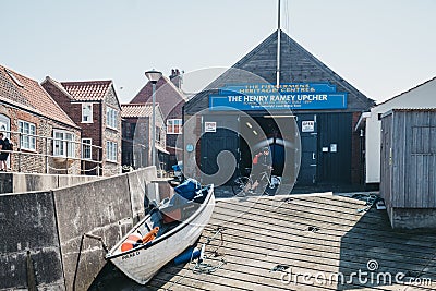 Woman cycles in front of The Henry Ramey Upcher, The Fishermans Heritage Centre in Sheringham, Norfolk, UK Editorial Stock Photo