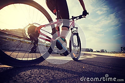 cyclist legs riding Mountain Bike on highway Stock Photo