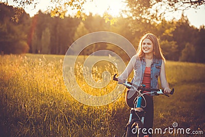 Woman cyclist rides in the forest on a mountain bike. Stock Photo