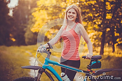 Woman cyclist rides in the forest on a mountain bike. Stock Photo