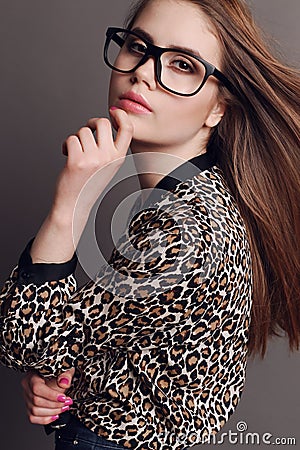 Woman with dark hair in elegant leopard print shirt and with glasses Stock Photo