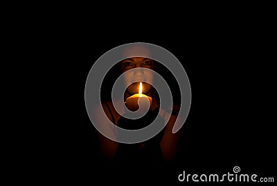 Woman in darkness with candle light Stock Photo