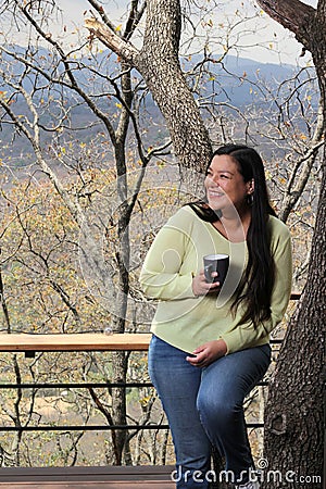 Woman at dawn in a cabin in the woods drinks coffee to activate the mind with caffeine because it is rich in antioxidants Stock Photo