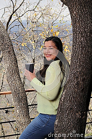 Woman at dawn in a cabin in the woods drinks coffee to activate the mind with caffeine because it is rich in antioxidants Stock Photo