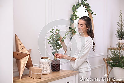 Woman decorating home interior with eucalyptus branches Stock Photo