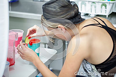 Woman decorating a refreshing natural beverage on a restaurant Stock Photo