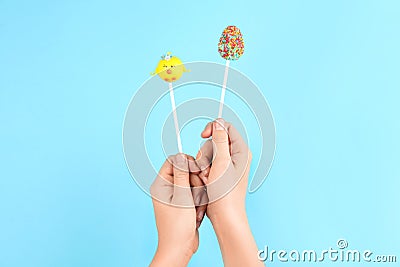 Woman with delicious cake pops on blue background, closeup. Easter holiday Stock Photo