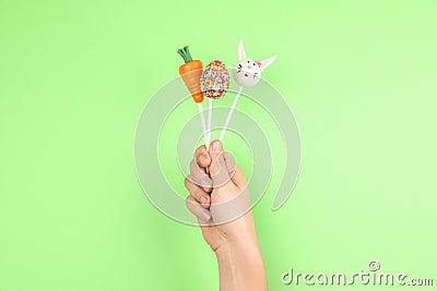 Woman with delicious cake pops on green background, closeup. Easter holiday Stock Photo