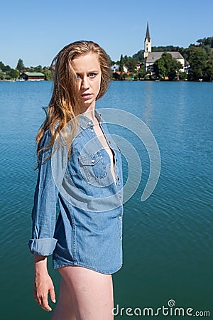 Woman in Denim Shirt Standing by Quiet Lake Stock Photo
