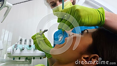 Woman dentist curing ladys teeth, doctor providing dental services, medicine Stock Photo