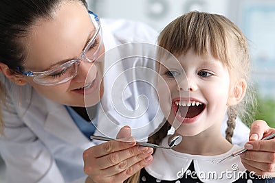 Woman dentist examines teeth in clinic at child Stock Photo