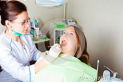 Woman dentist making a review of patient mouth Stock Photo