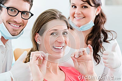 Woman at dentist using dental floss Stock Photo