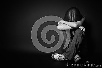 Woman in depression and despair crying on black dark Stock Photo